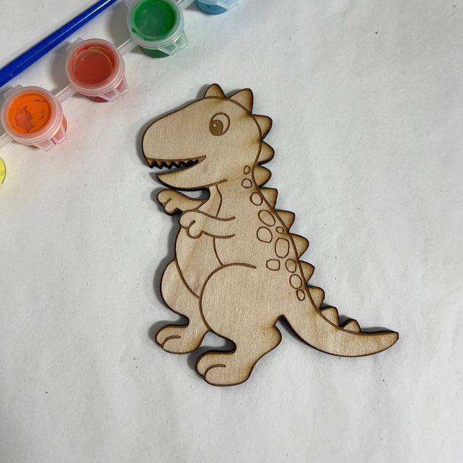 Wooden dinosaur cutout with paint containers and a brush on a white background