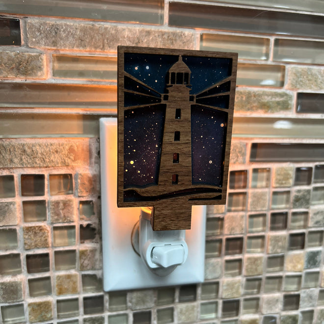 Decorative night light with night time design on a tiled wall.