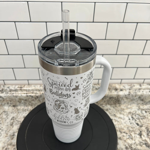 Tumbler with decorative text attached with a handle, lid and straw.