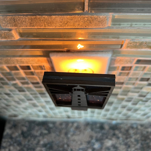 Decorative wall light fixture on a textured wall with a warm glow