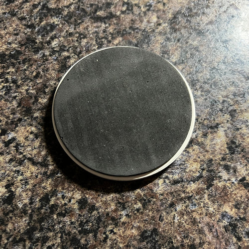 Round felted object on a textured brown surface