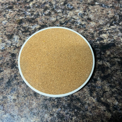 Round brown stone on a dark granite surface