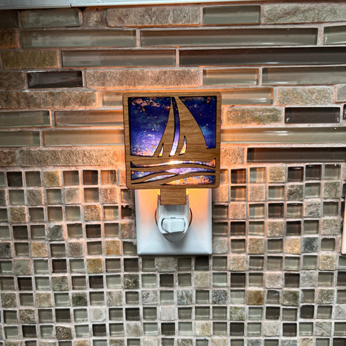 Sailboat night light turned on with backlit blue on a tiled surface