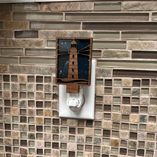 Tiled wall with a decorative lighthouse plug in light switch.
