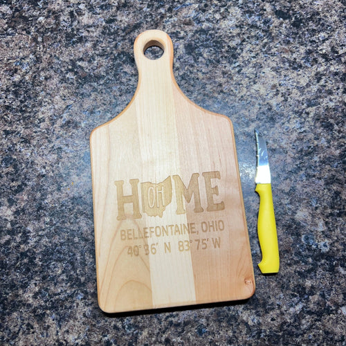 Wooden cutting board with engraved text on a dark granite surface