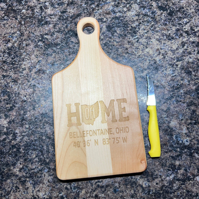 Wooden cutting board with engraved text on a dark granite surface