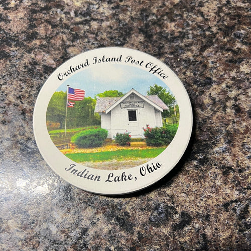 Round sticker with a scenic design of a building and trees on a textured surface