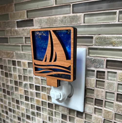 Decorative night light with sailboat design on a tiled wall